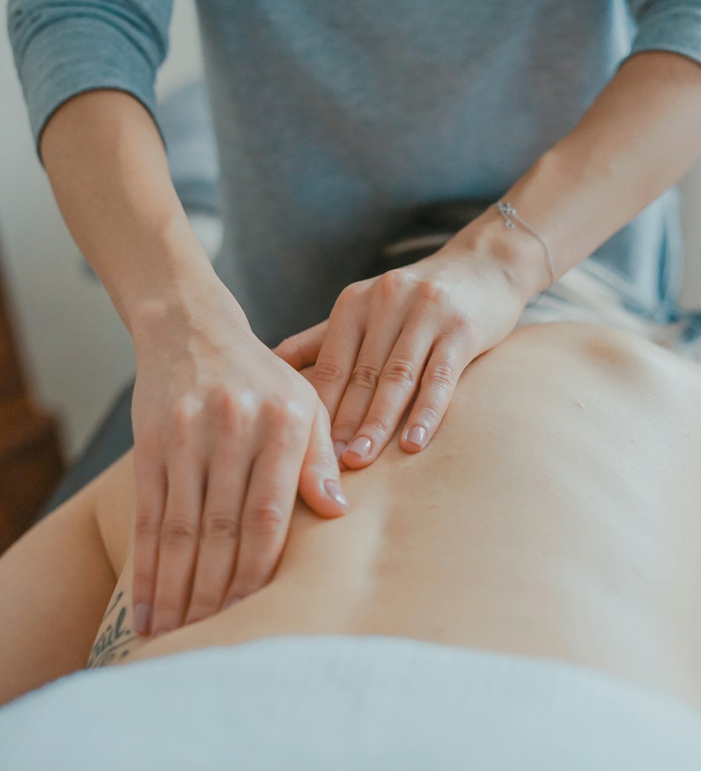 Therapist applying pressure along a patient's spine during treatment
